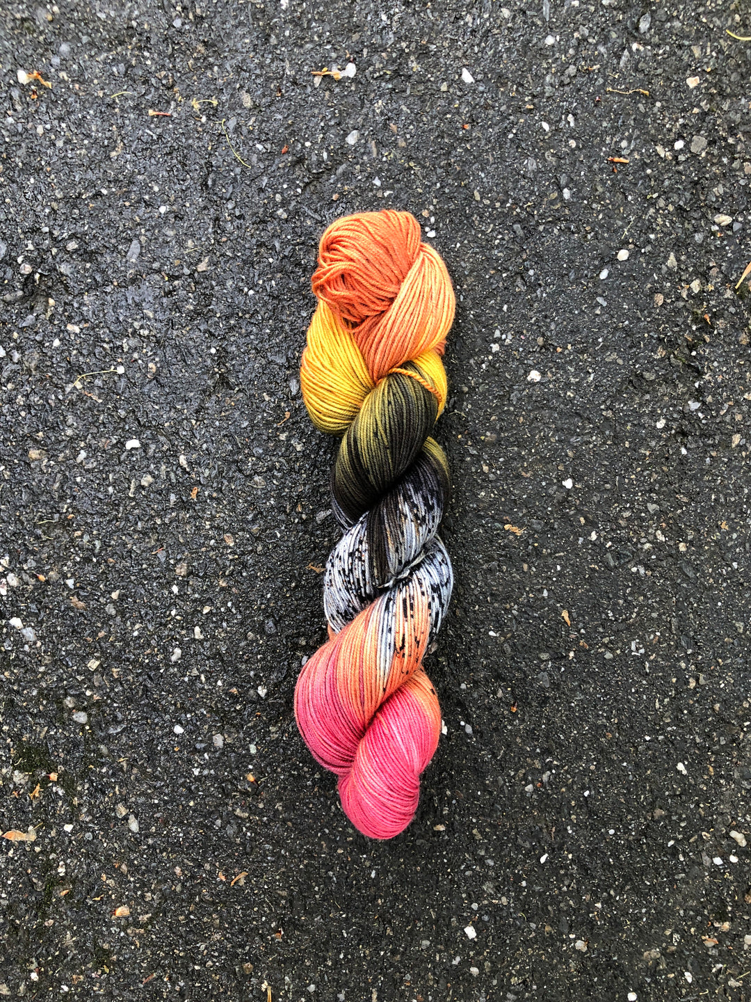 Yarn in shades of orange, yellow, green, black, white, peach and hot pink.