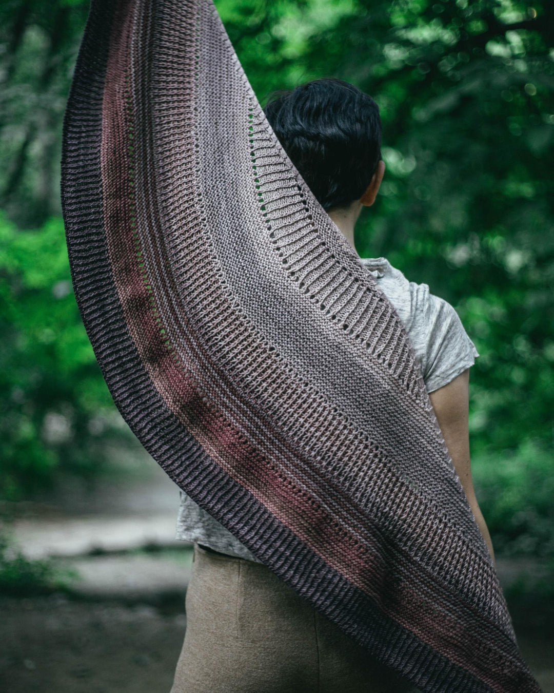 A light gray, pink and dark gray textured shawl.