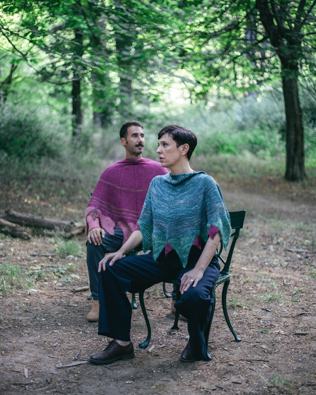 A man and a woman wearing purple and blue shawls.