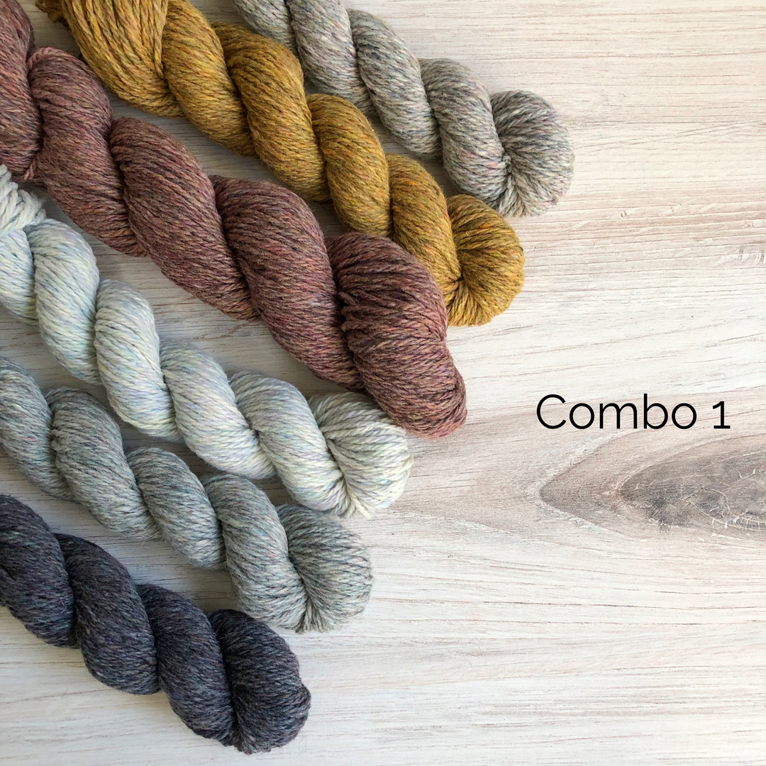 Skeins of gray, white, pink and yellow yarn.