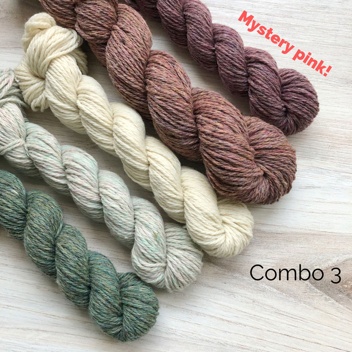 Skeins of green, white and pink yarn, with the words mystery pink.