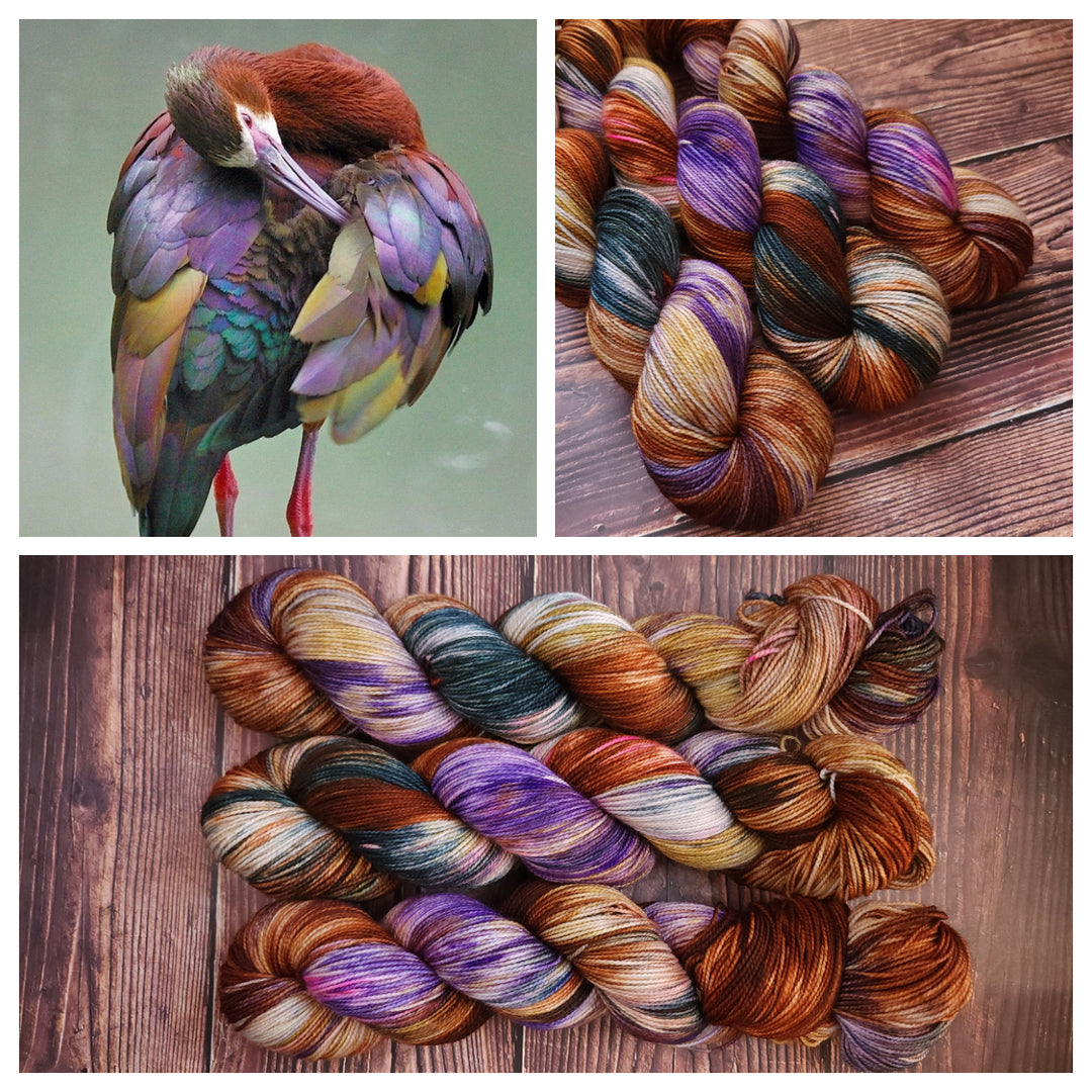 A bird in purple, brown, green and gold and hand-dyed yarn in the same colors.