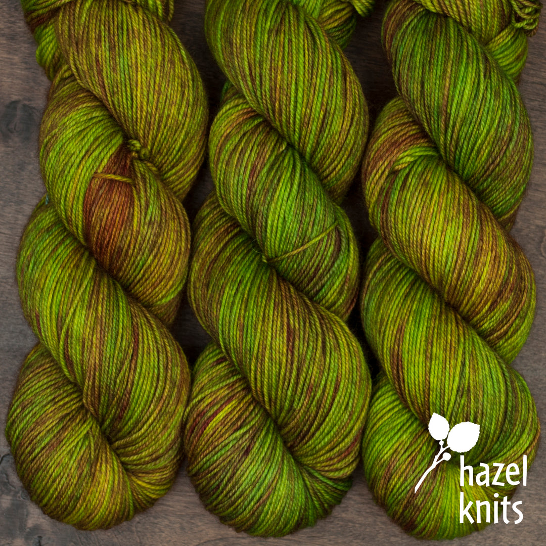 Green and brown yarn and the hazel knits logo.