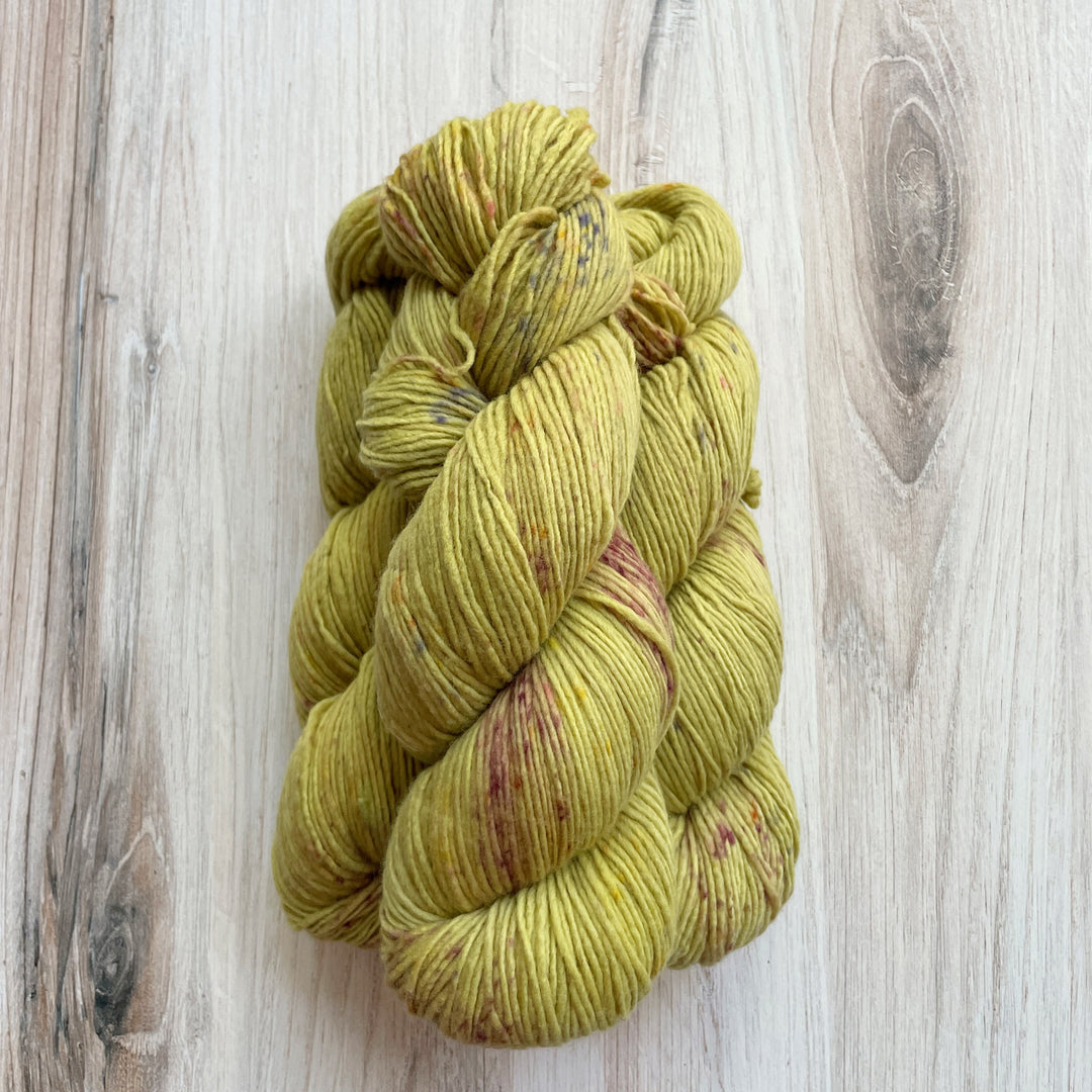 Green yarn speckled with purple.