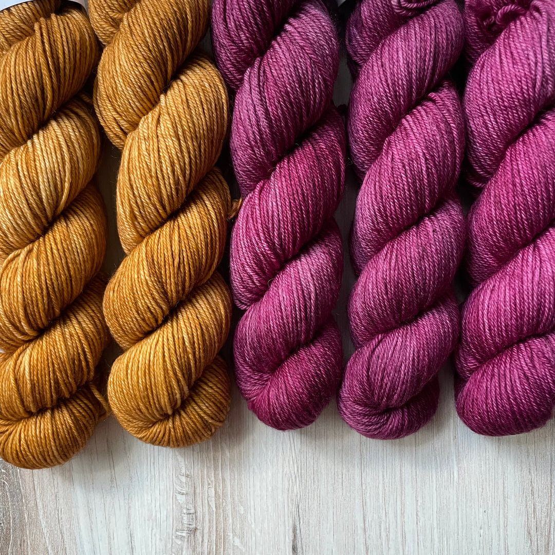 Twisted skeins of orange and purple yarn.