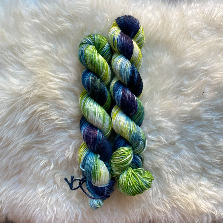 Hand-dyed yarn in deep indigo, vibrant green and bright blue hues.
