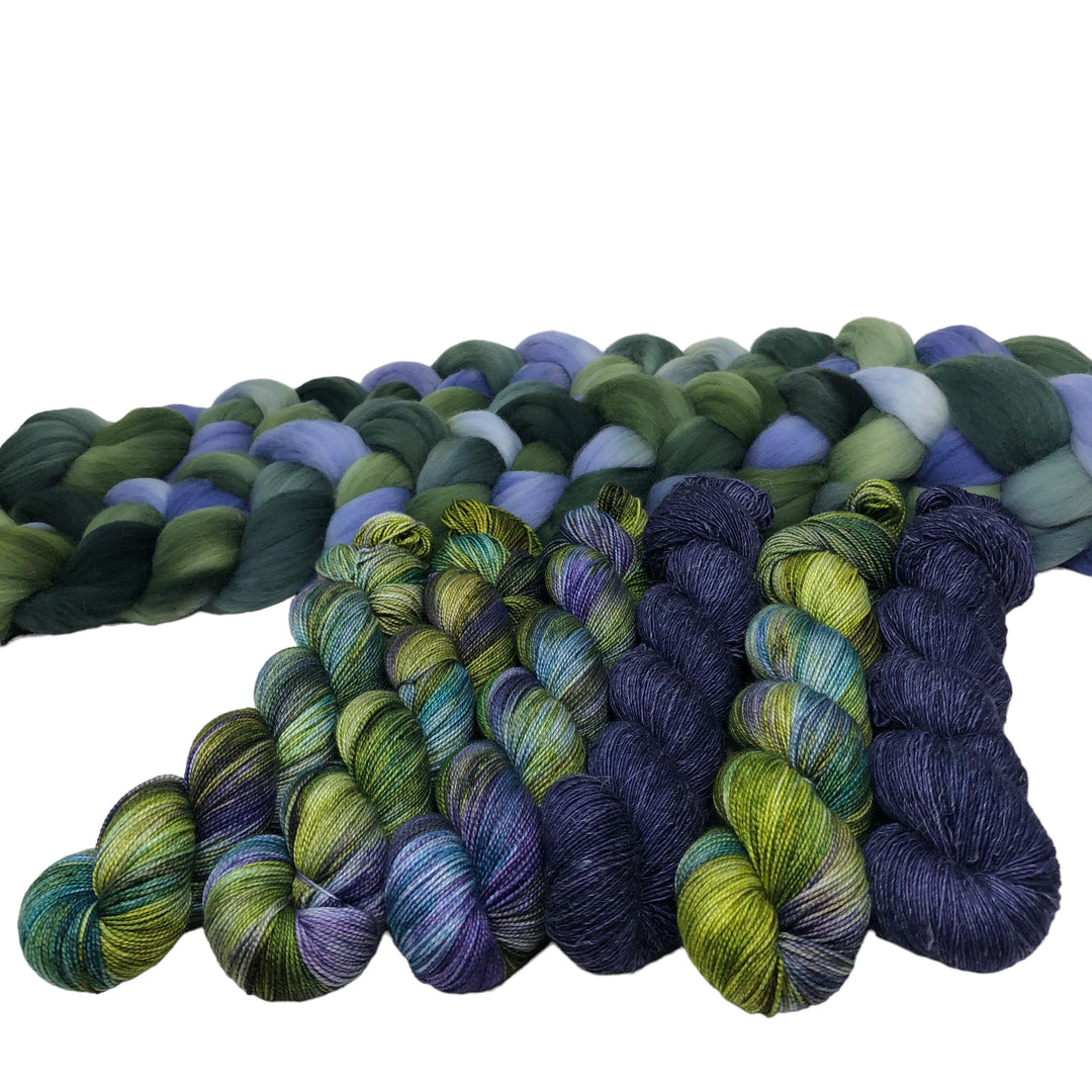 Skeins of hand-dyed yarn in various shades of green, blue, and purple and a close-up of braided fiber in similar colors.