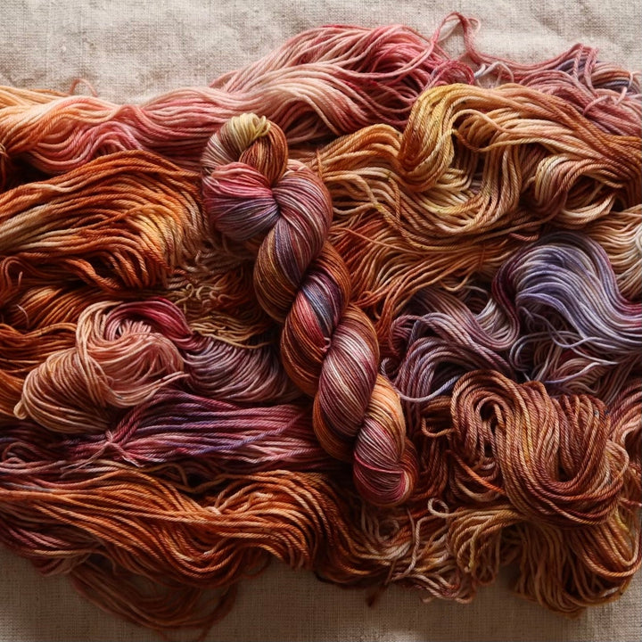 A bundle of skeins in warm, earthy hues.