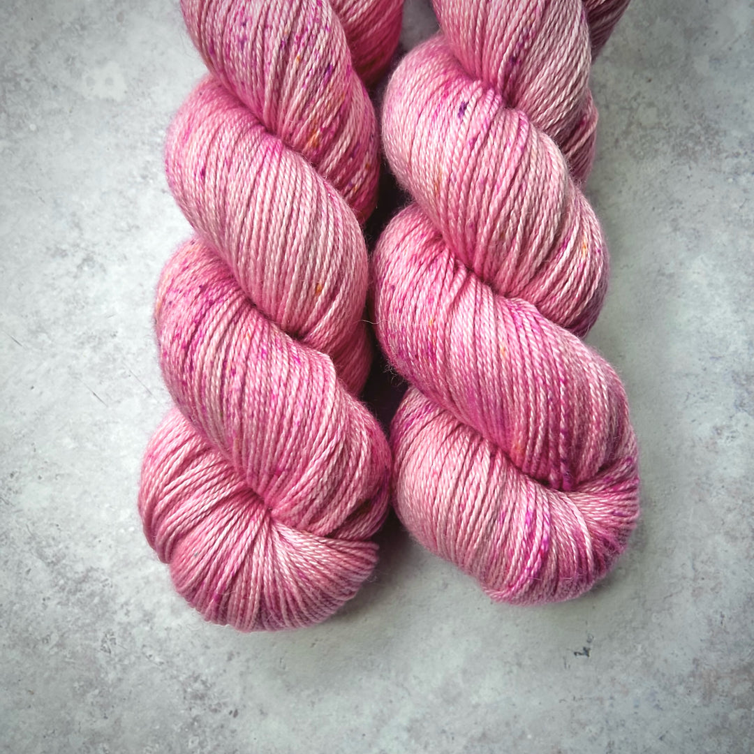 Skeins of pink lightly speckled yarn.