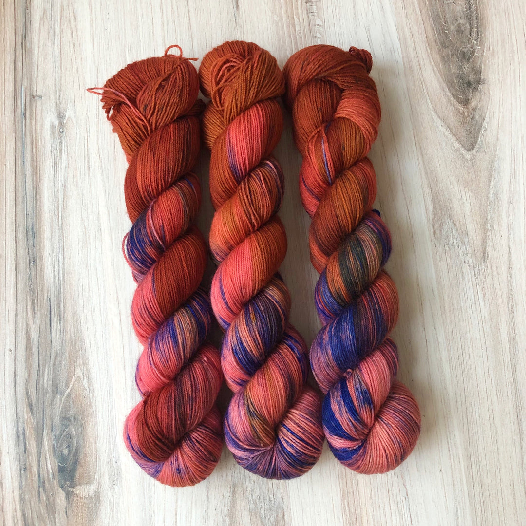 Skeins of red and blue hand-dyed variegated yarn.