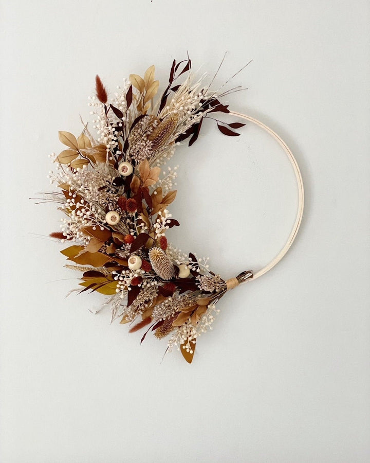 A wreath of brown and orange flora.