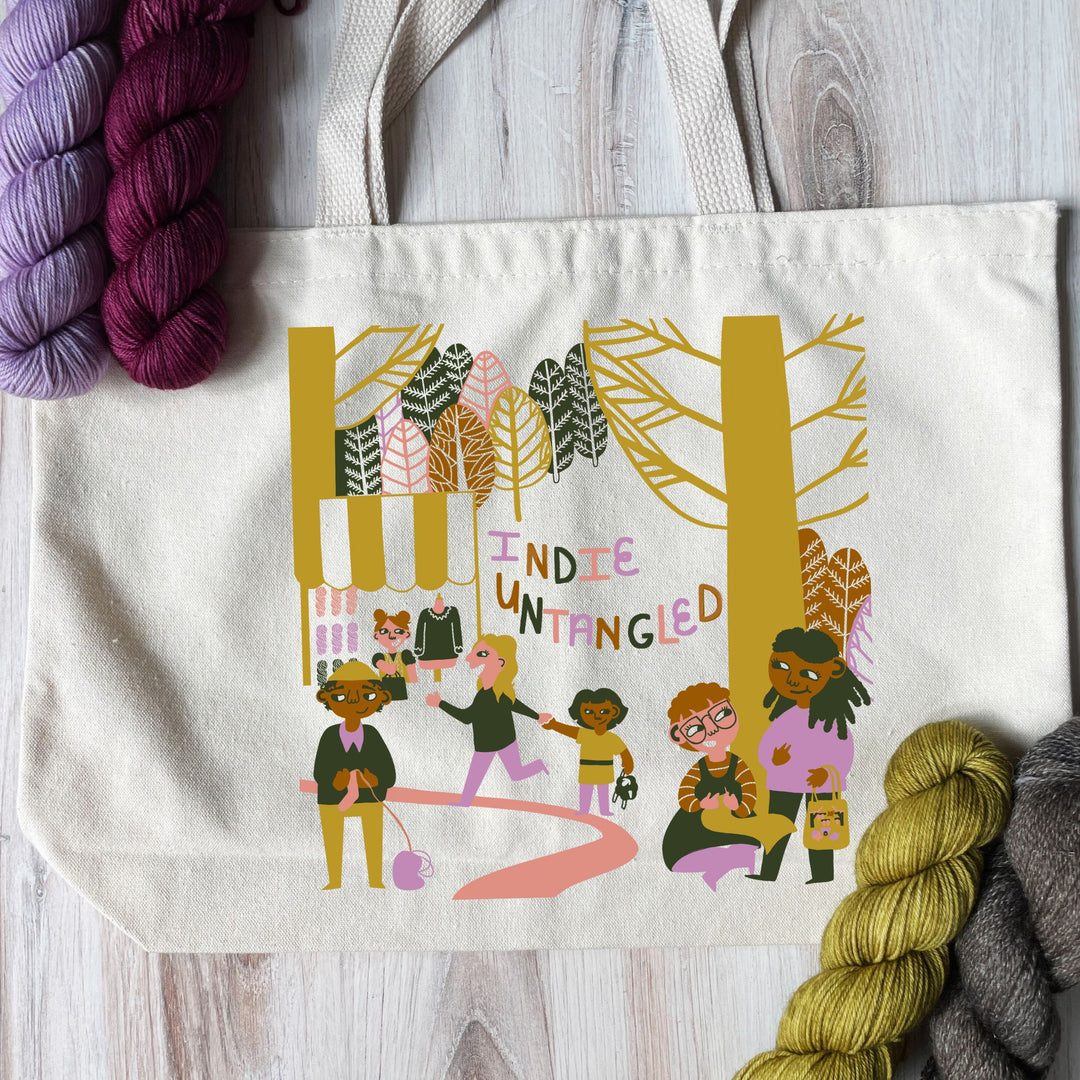 A tote bag with a gold, brown, pink, purple and gray illustration.