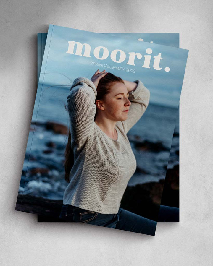 The cover of Moorit magazine featuring a light-skinned woman wearing a beige crochet top on a beach.