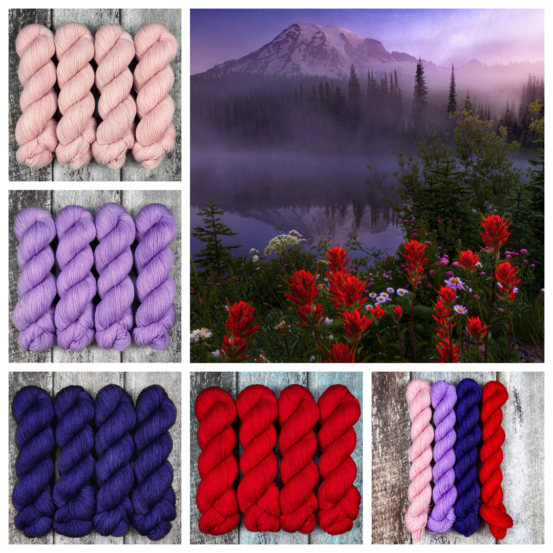Red and purple wildflowers at the base of a mountain, with skeins of pale pink, purple, deep blue and red yarn.