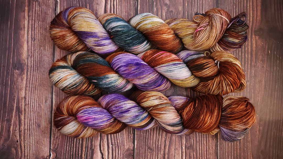 Purple, brown, green and gold hand-dyed yarn.