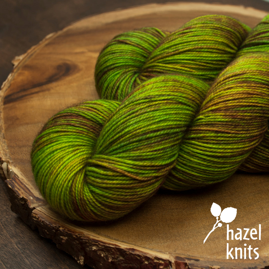 Green and brown yarn and the hazel knits logo.