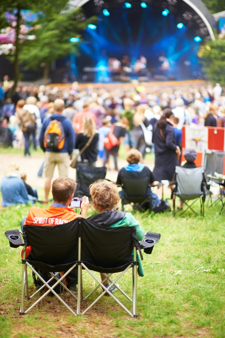 People sitting at an outdoor music festival.