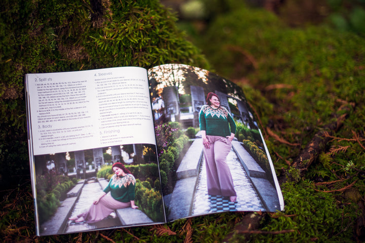 A book open to a picture of a woman wearing a green sweater with a pale pink colorwork yoke.