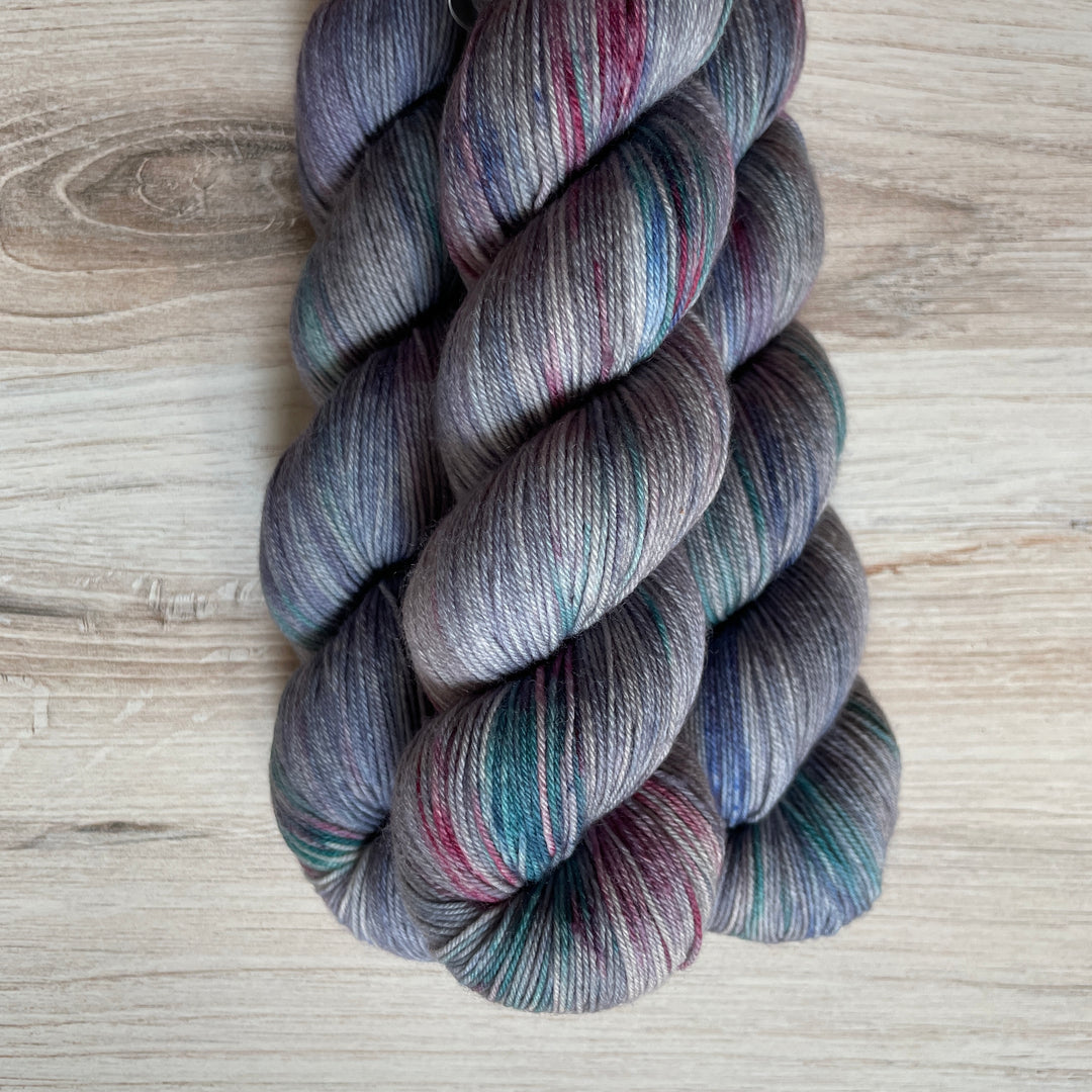 Gray yarn speckled with blue and purple.