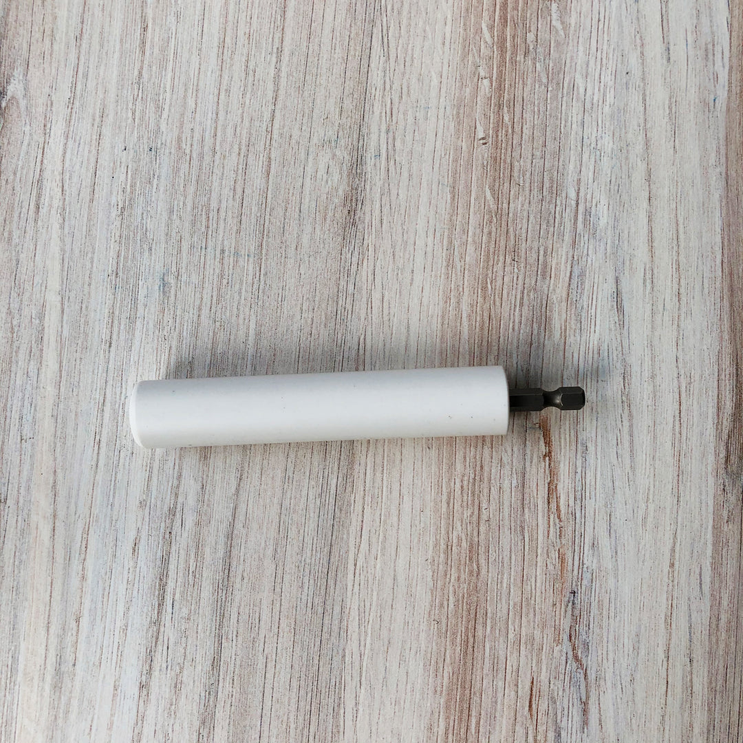 A white plastic stick with a metal piece at the end.