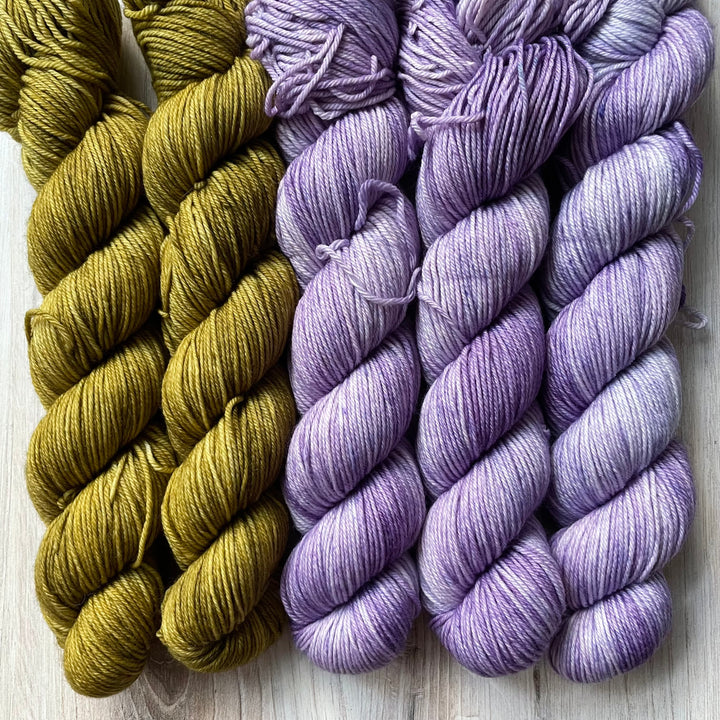 Twisted skeins of green and purple yarn.