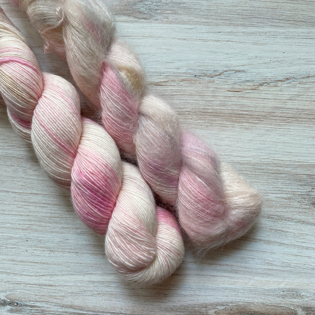 Cream colored yarn speckled with pink.