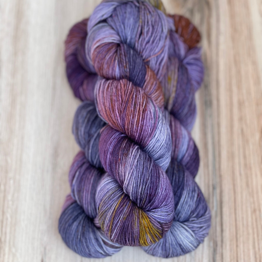 Skeins of purple yarn with gold speckles.