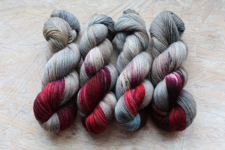 Gray-blue yarn with bands of red and purple.